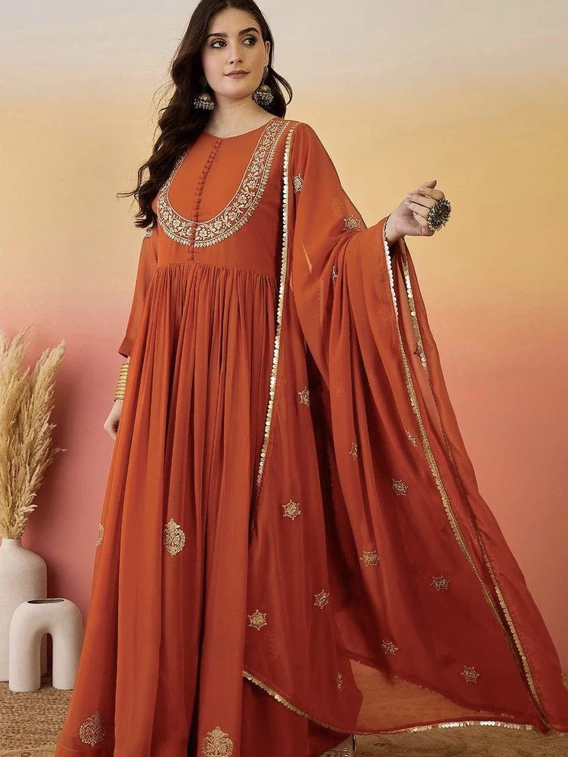 Woman wearing an orange traditional outfit with gold embroidery against a warm gradient background