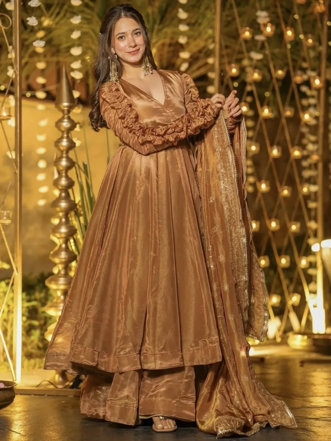 Woman in a bronze traditional outfit with a decorative background