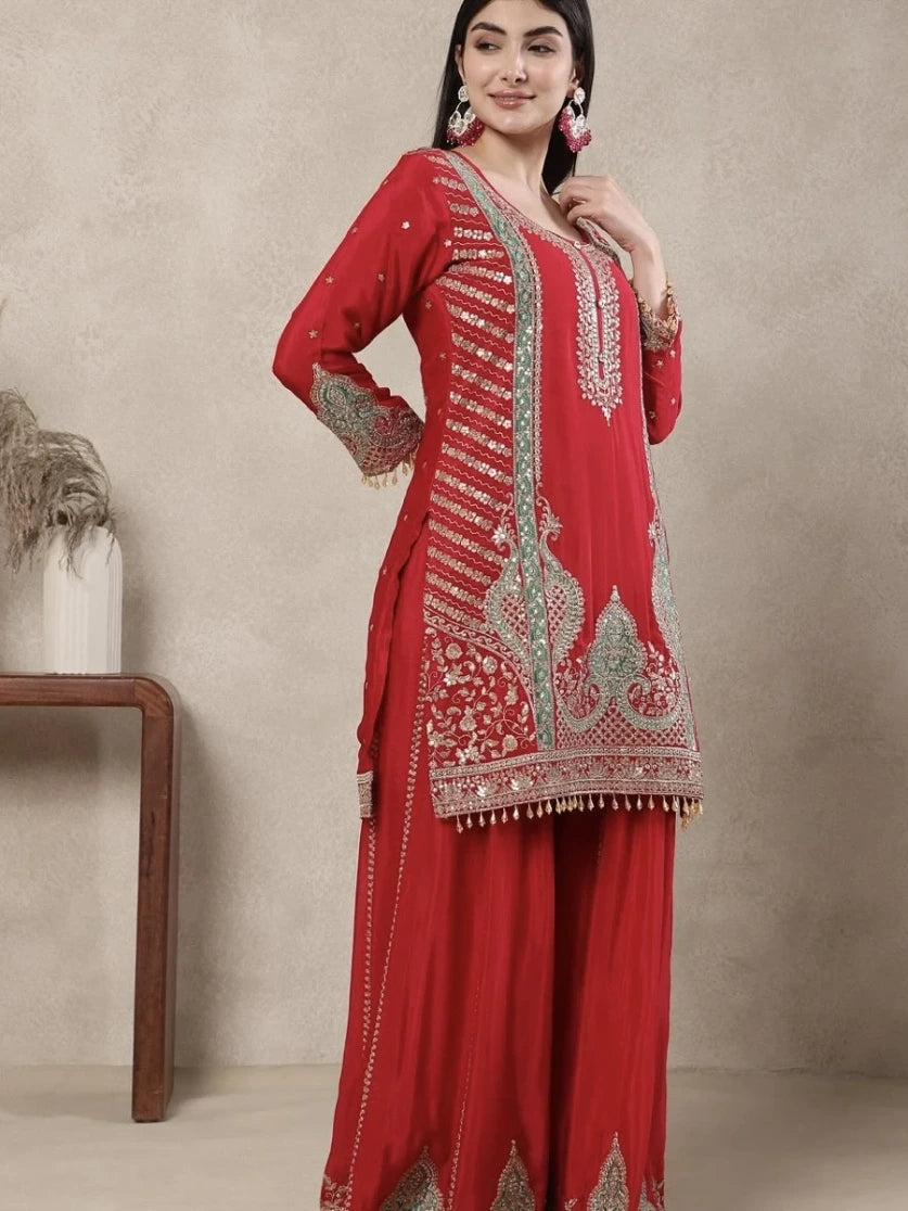 Red embroidered traditional outfit on a neutral background