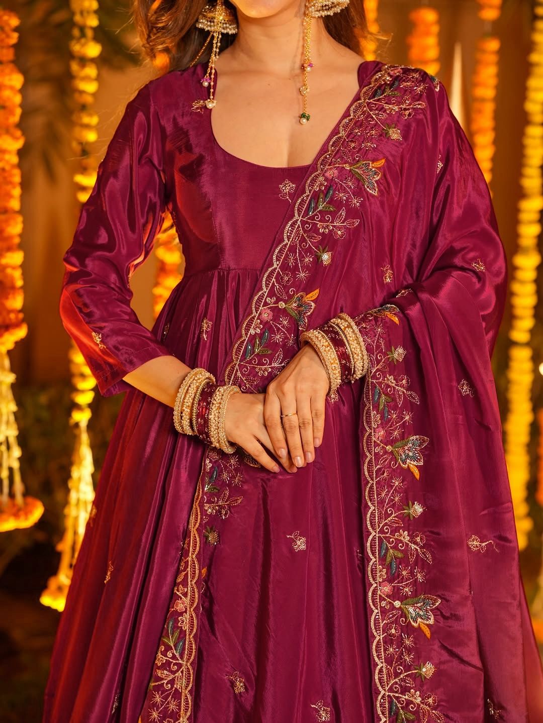 Purple embroidered traditional outfit with gold details against a warm-toned background