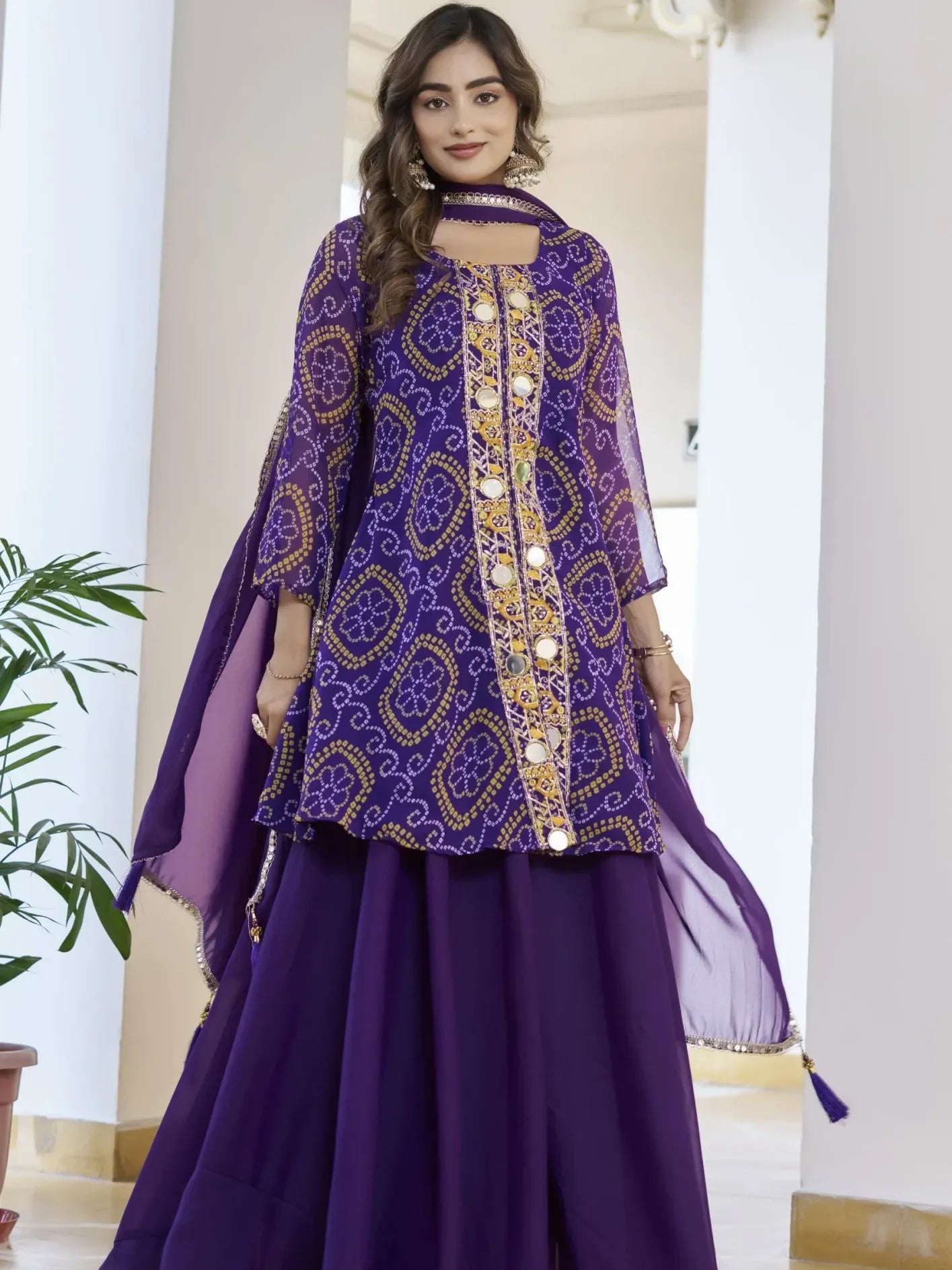 Woman wearing a purple traditional outfit with gold patterns indoors.