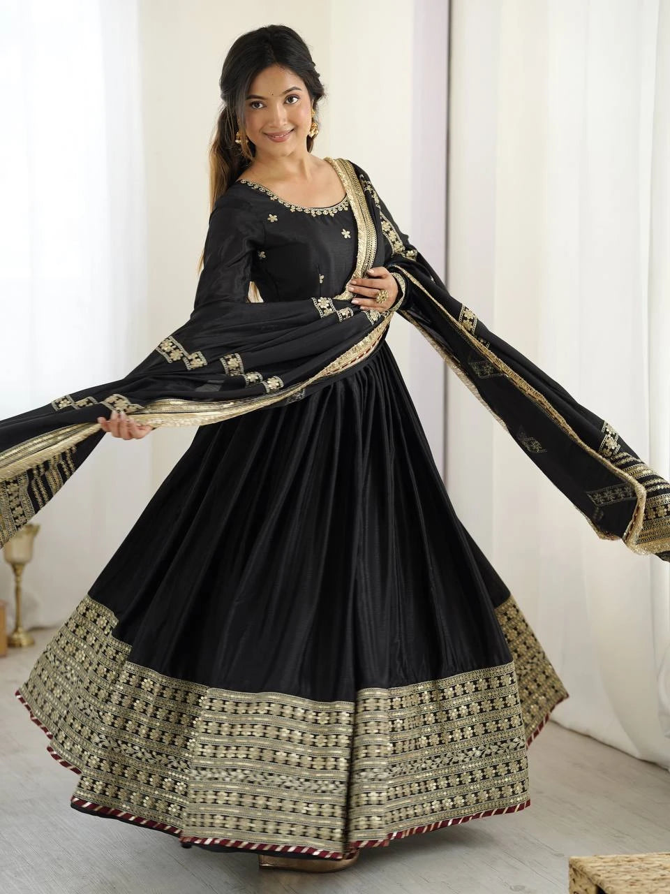 Woman wearing a black and gold traditional outfit with a white background