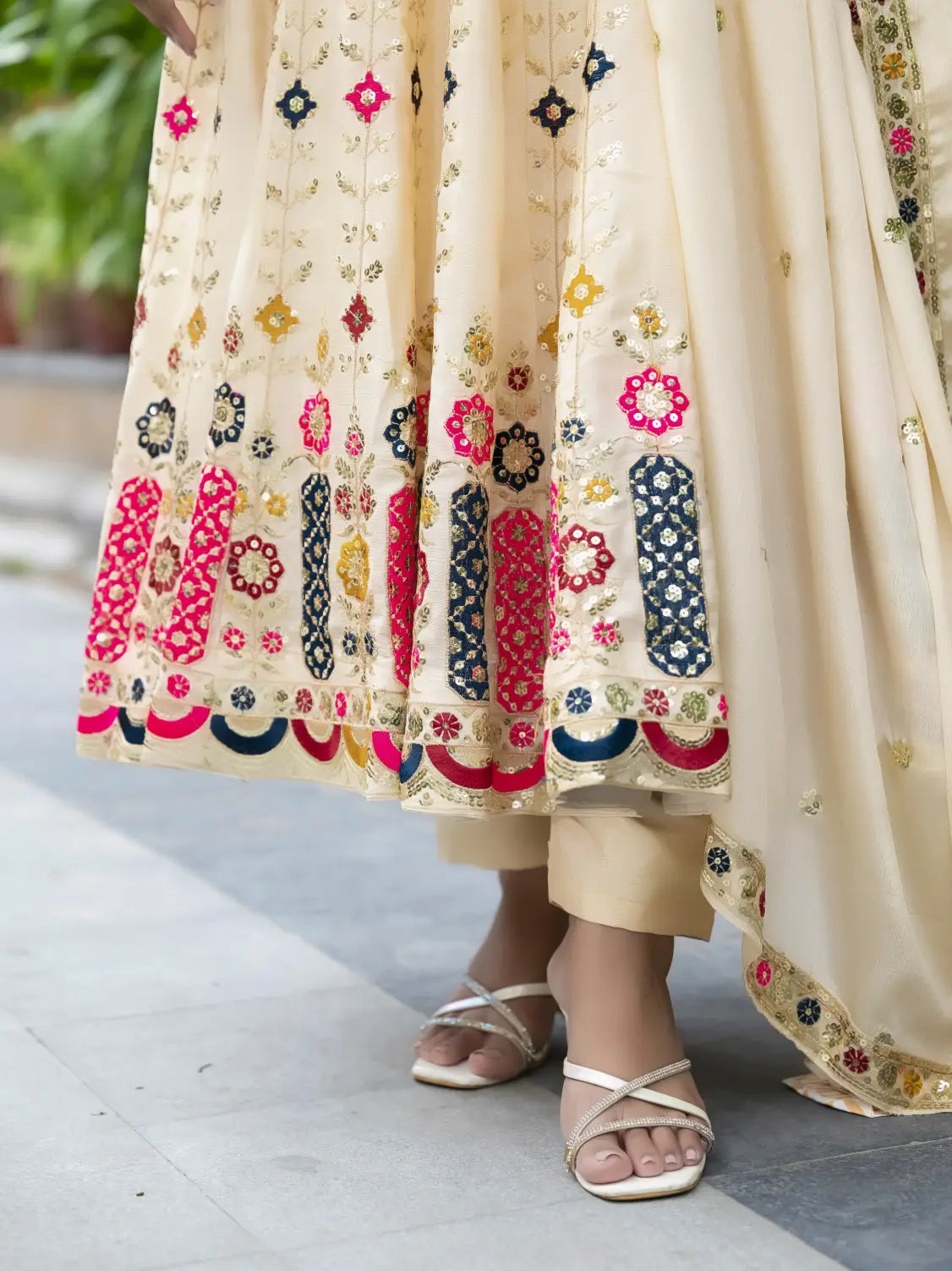 Beige traditional outfit with colorful floral embroidery on a blurred background