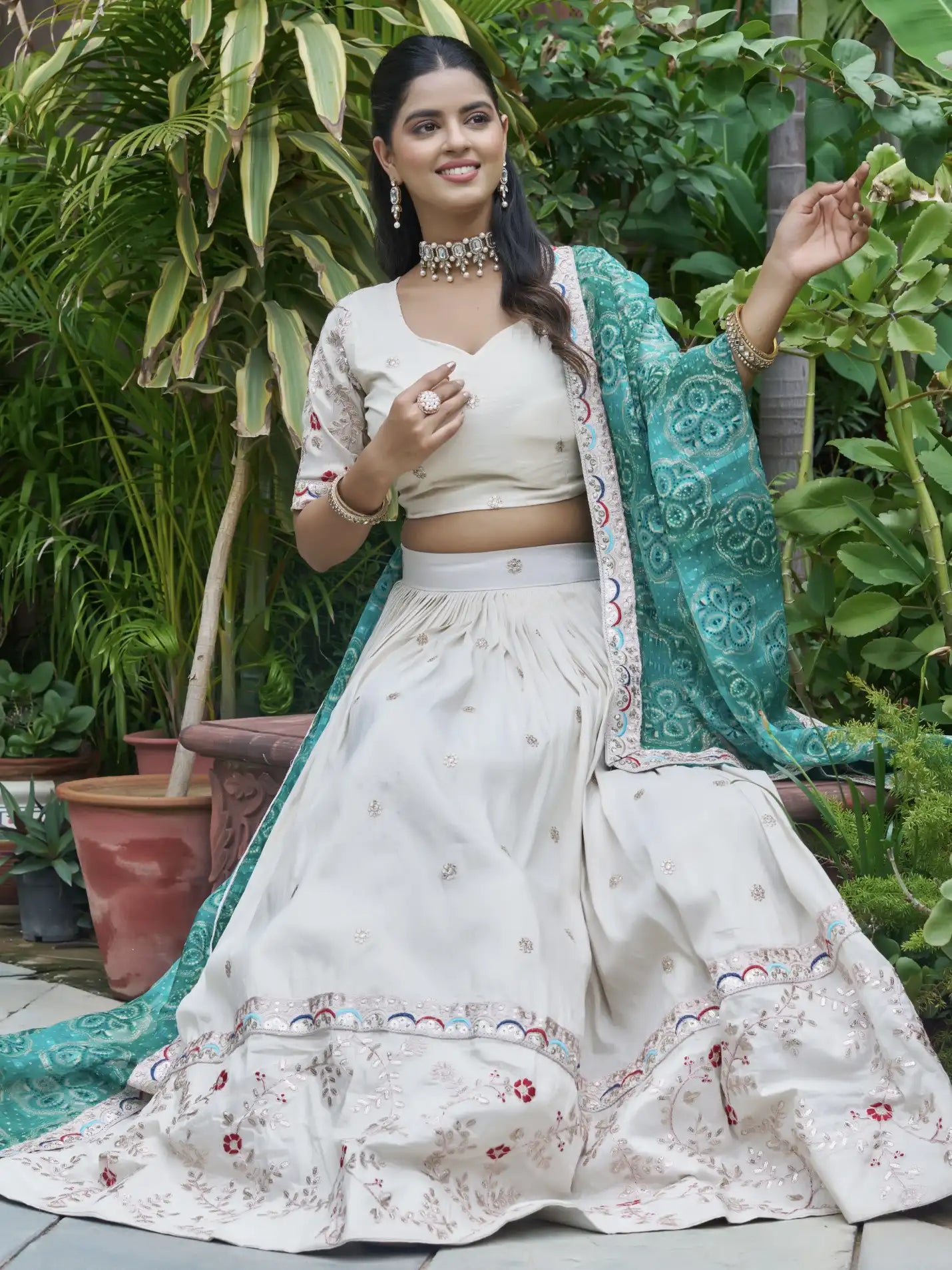 Woman in a traditional outfit with a green dupatta in a garden setting
