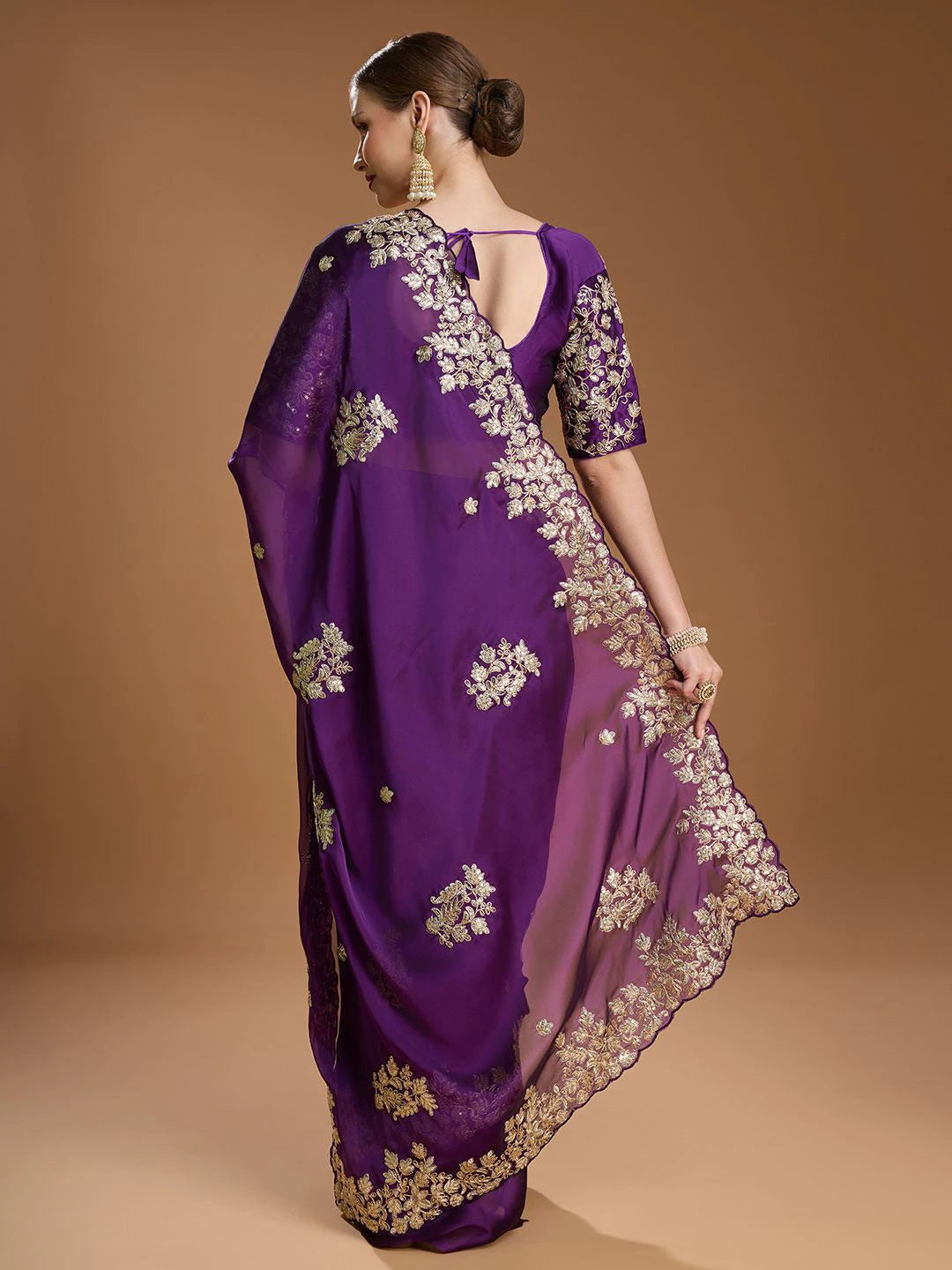 Purple saree with floral embroidery on a brown background