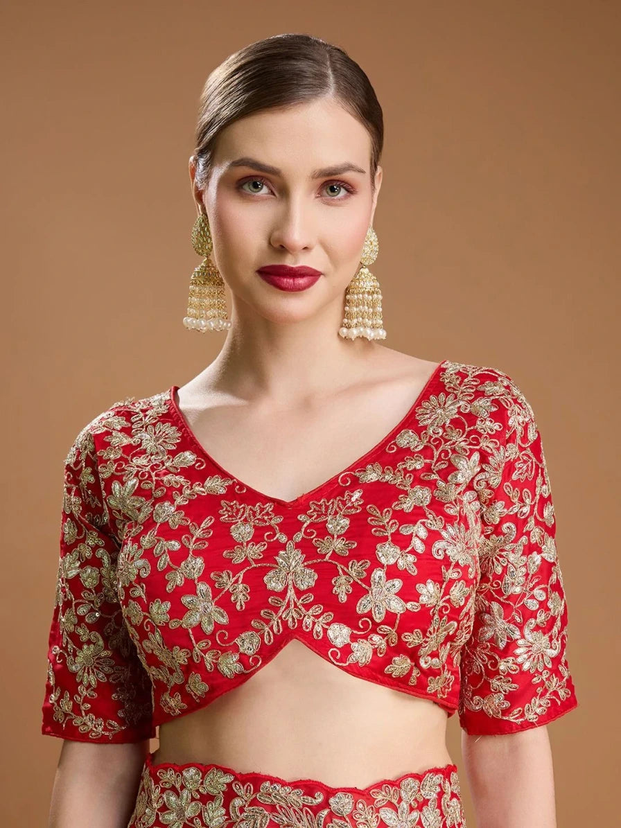 Woman wearing a red and gold embroidered blouse against a brown background