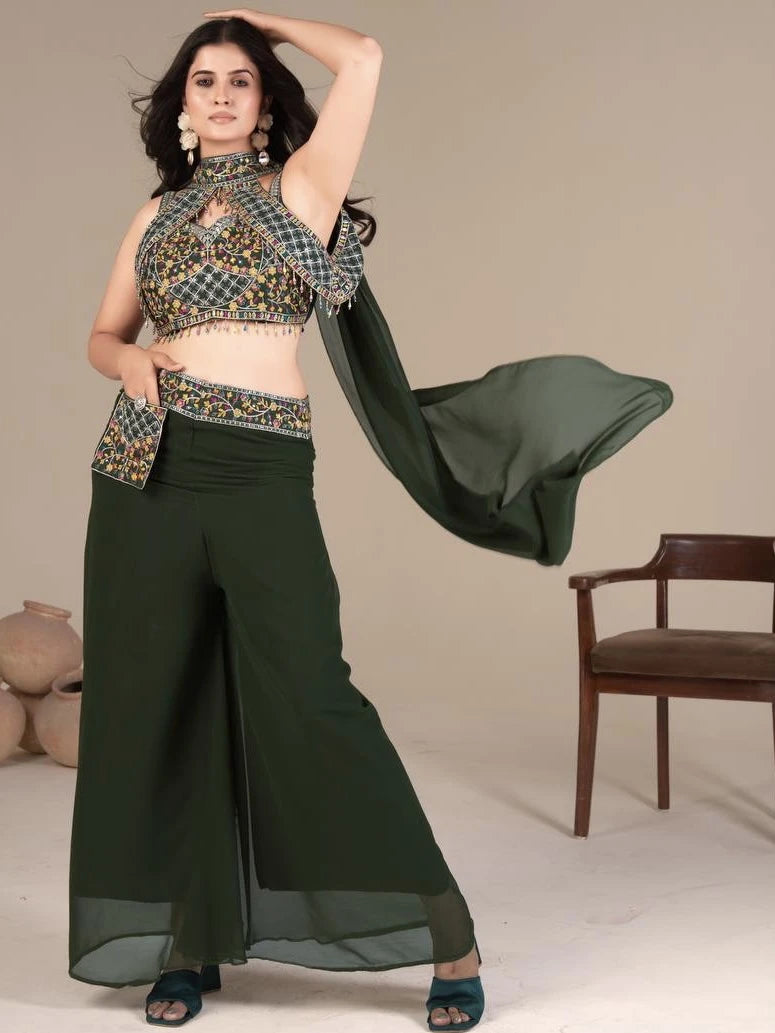 Woman in a traditional outfit with a green saree and patterned blouse against a neutral background.