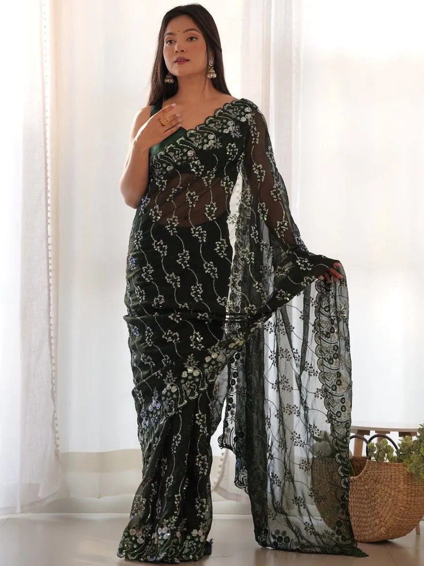 Woman wearing a black floral saree with a white background