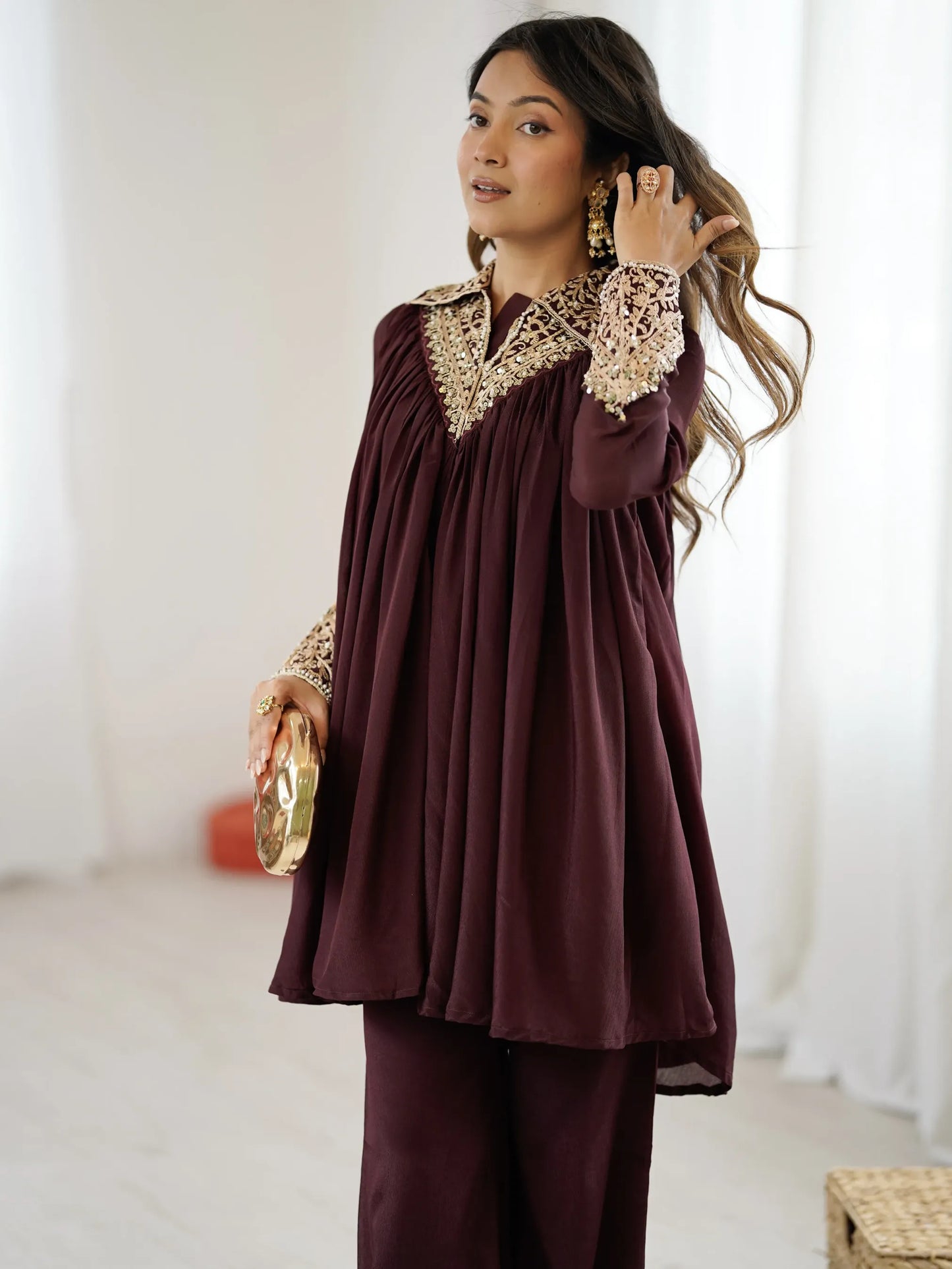 Woman wearing a burgundy outfit with lace details indoors.