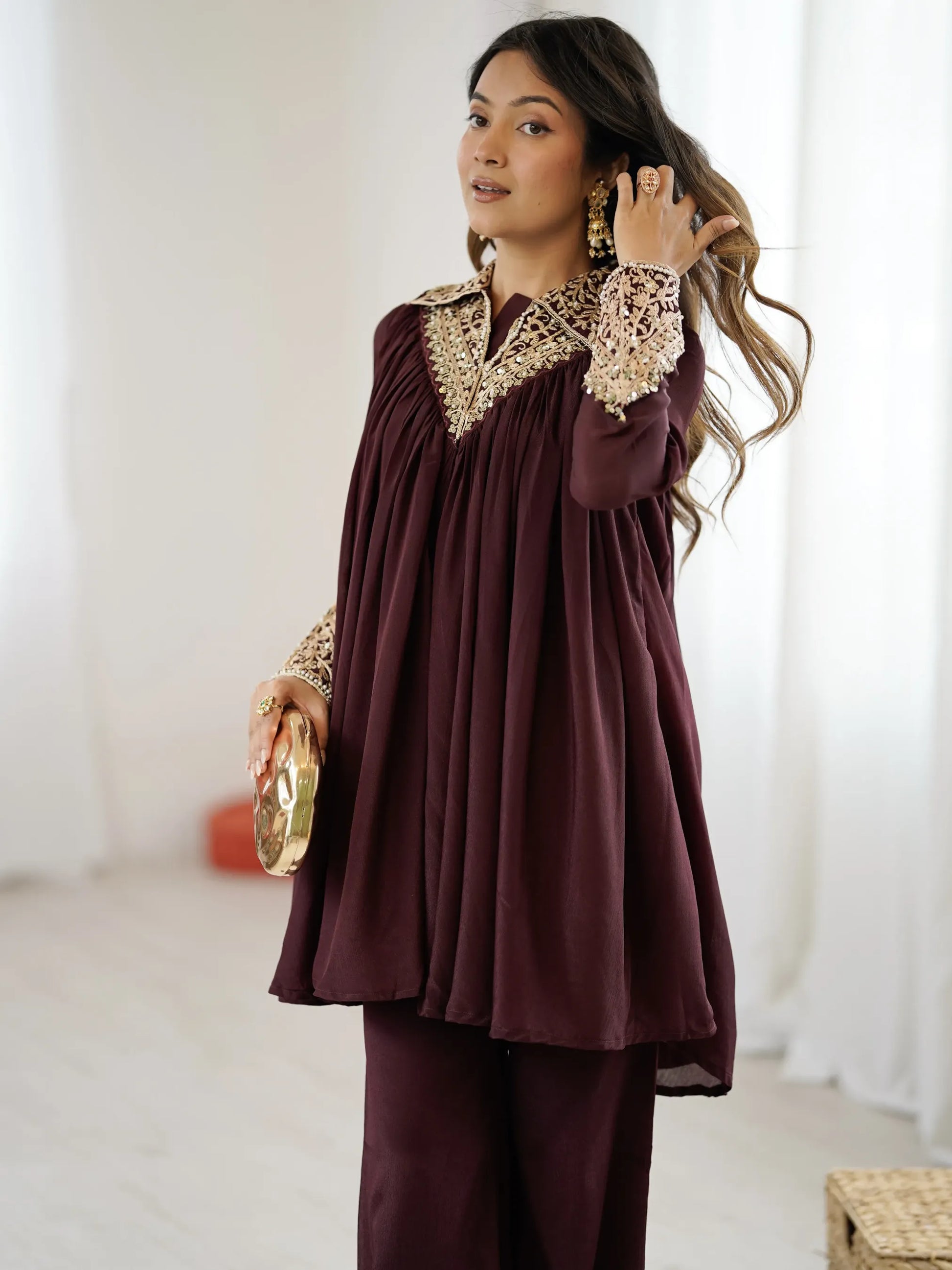 Woman wearing a burgundy outfit with lace details indoors.