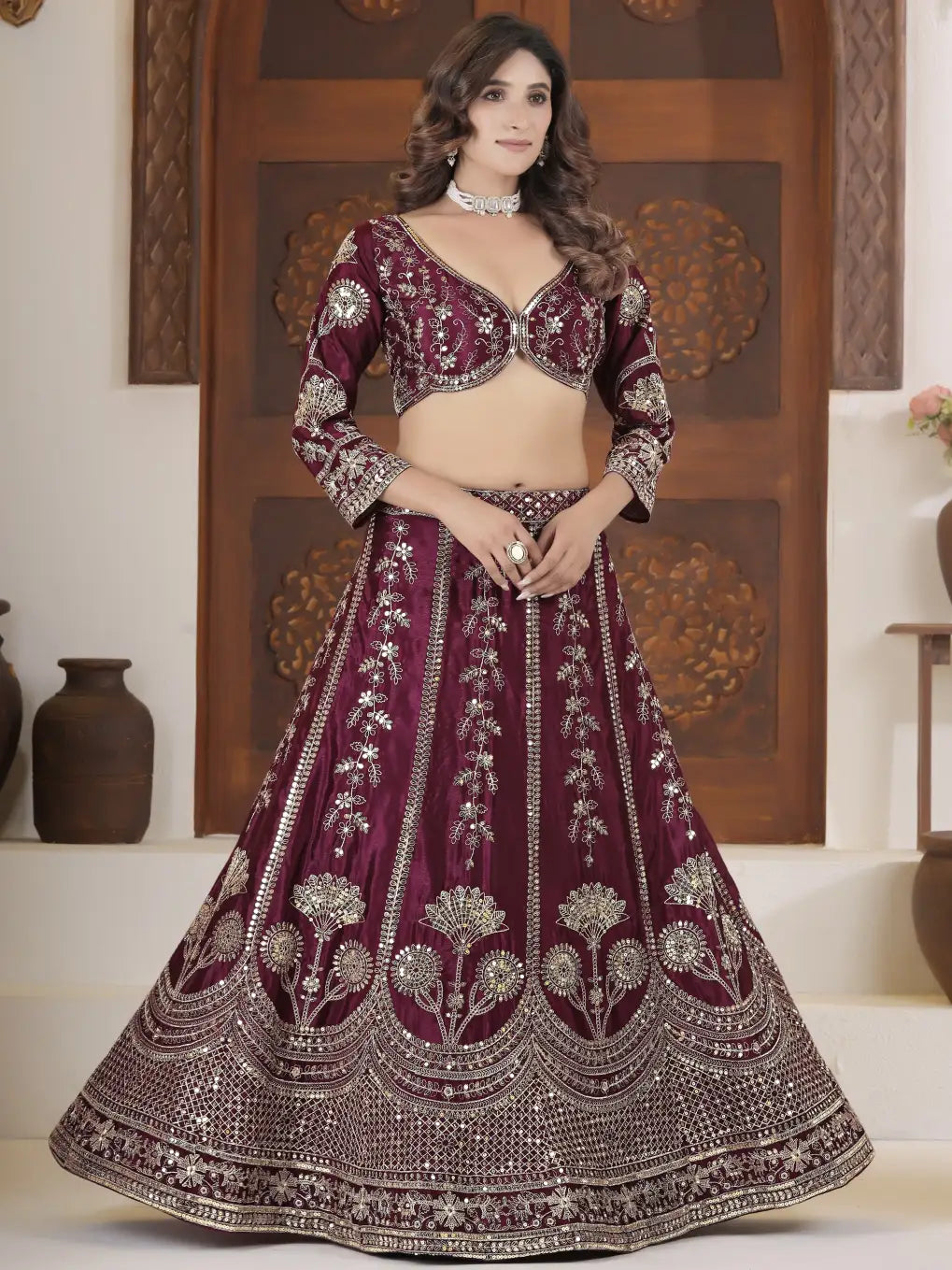 Woman wearing a maroon embroidered traditional outfit with a wooden panel background