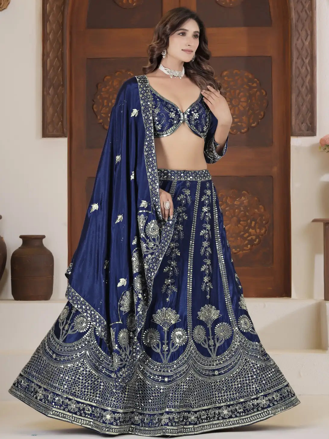 Woman wearing a blue embroidered traditional outfit with a wooden panel background