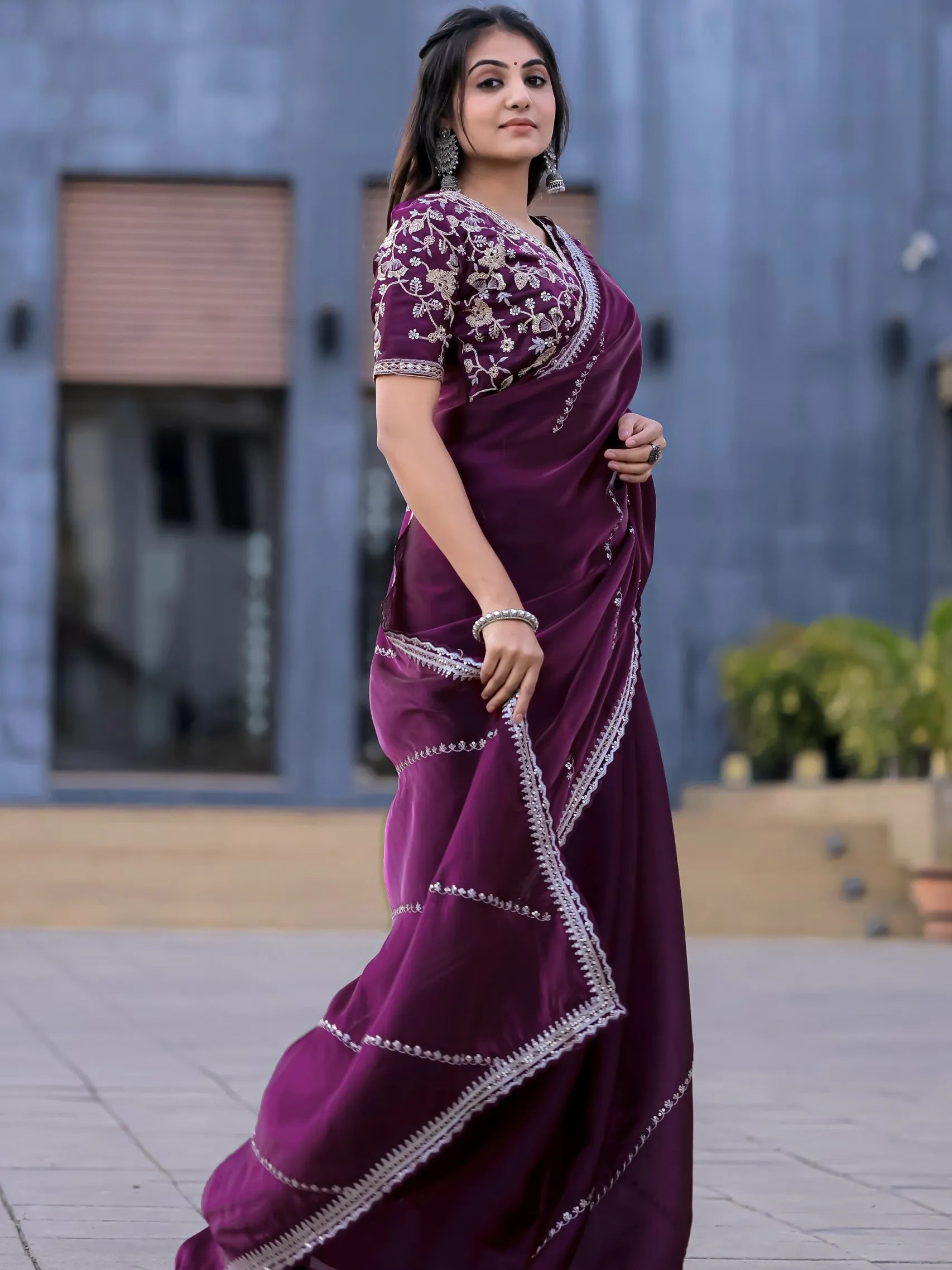 Woman wearing a purple saree with white border outdoors