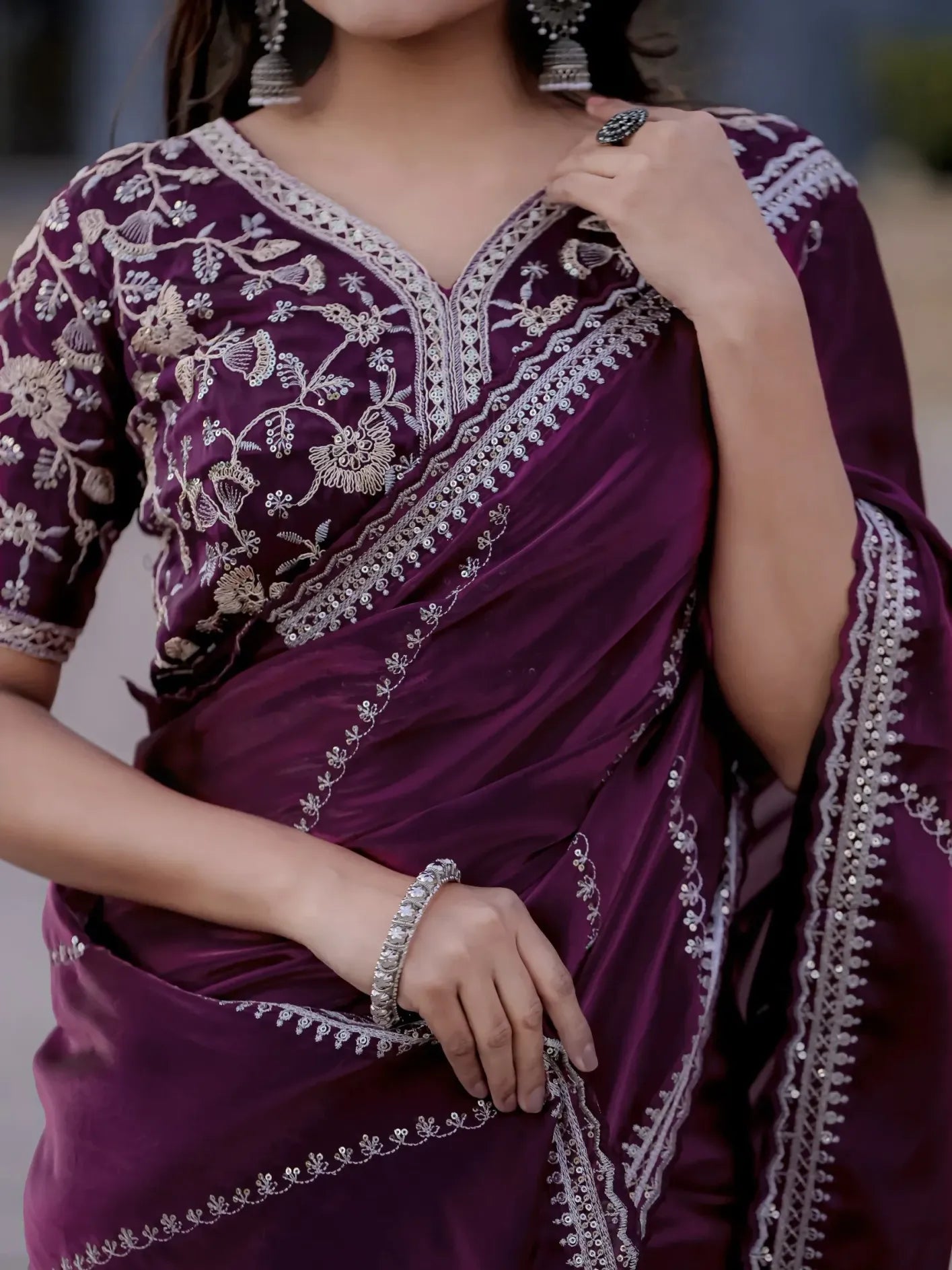 Purple saree with intricate white embroidery worn by a person.