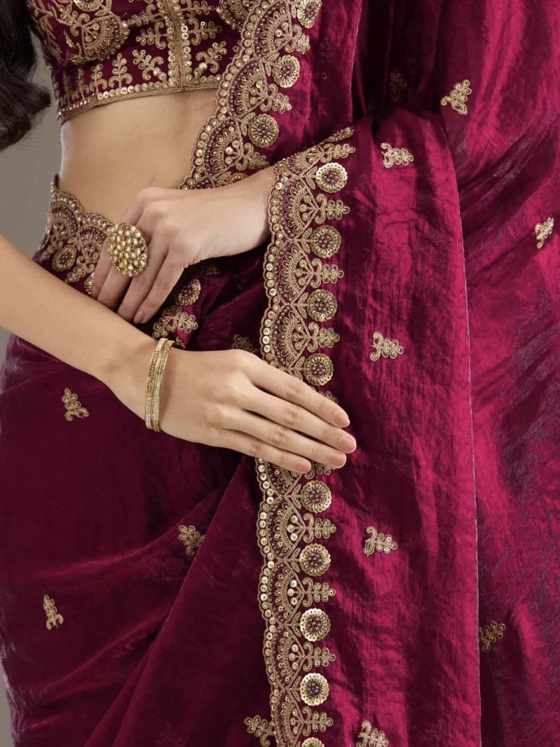 Maroon saree with gold embroidery and a close-up of hands wearing jewelry.