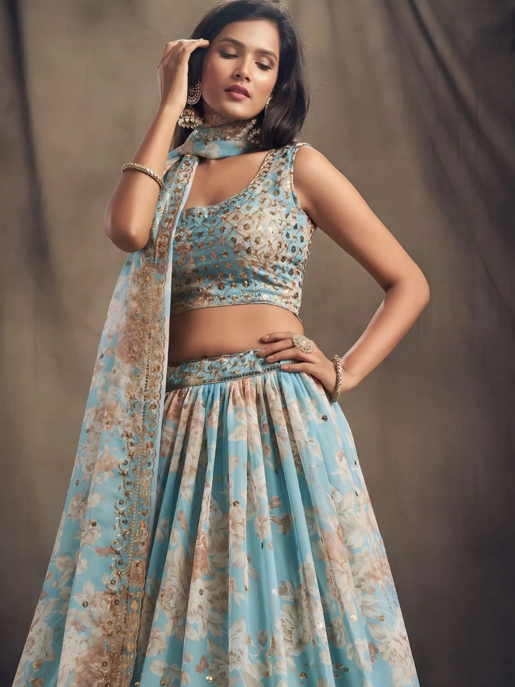 Woman wearing a floral dress with a matching dupatta against a plain background