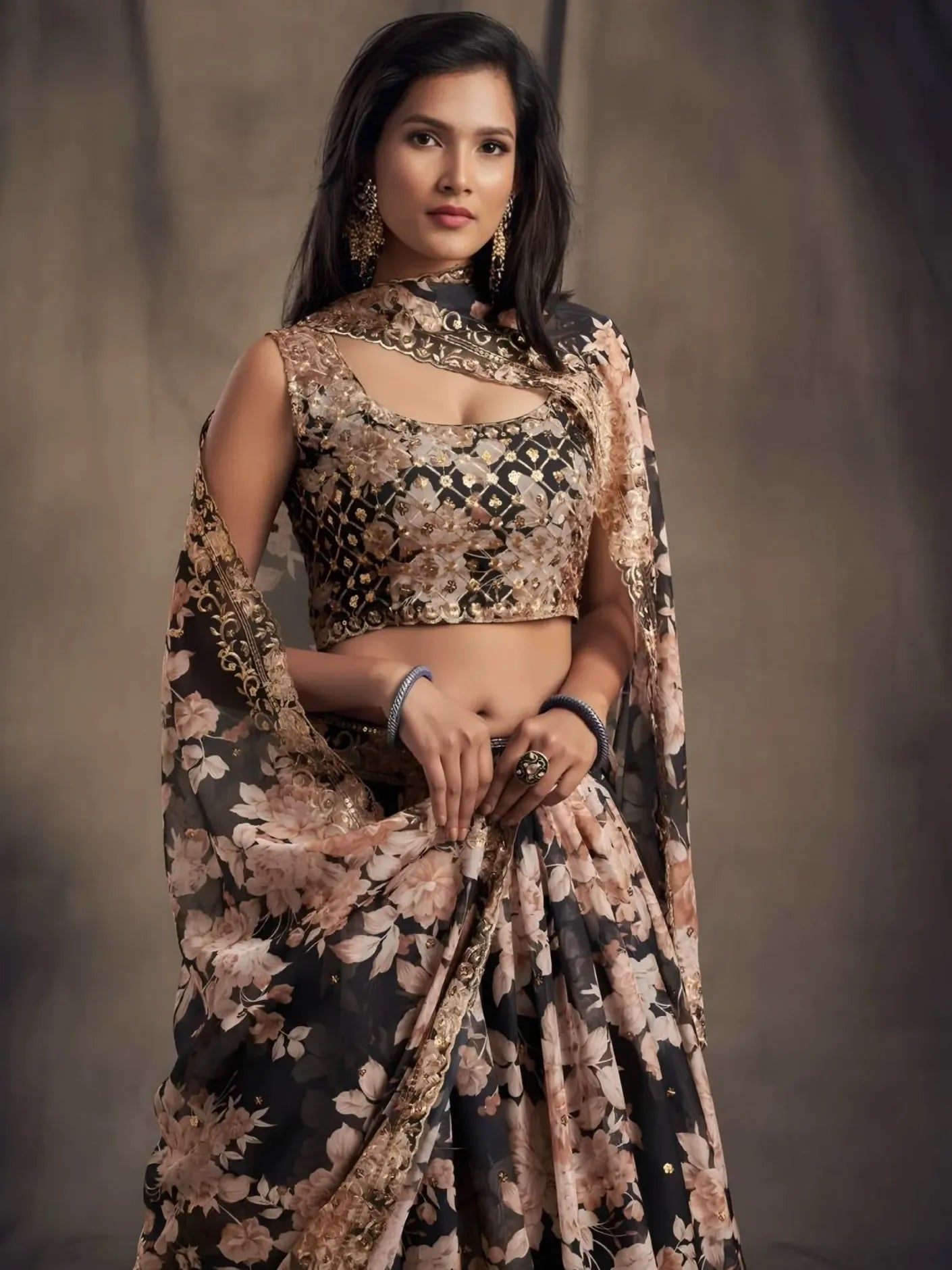Woman wearing a floral saree with a matching blouse against a neutral background