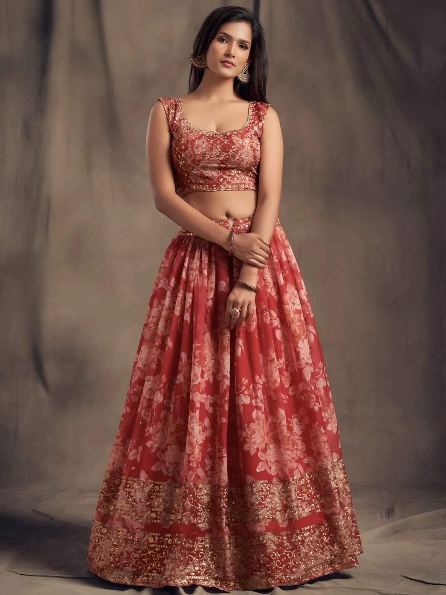 Woman wearing a red floral dress against a plain background