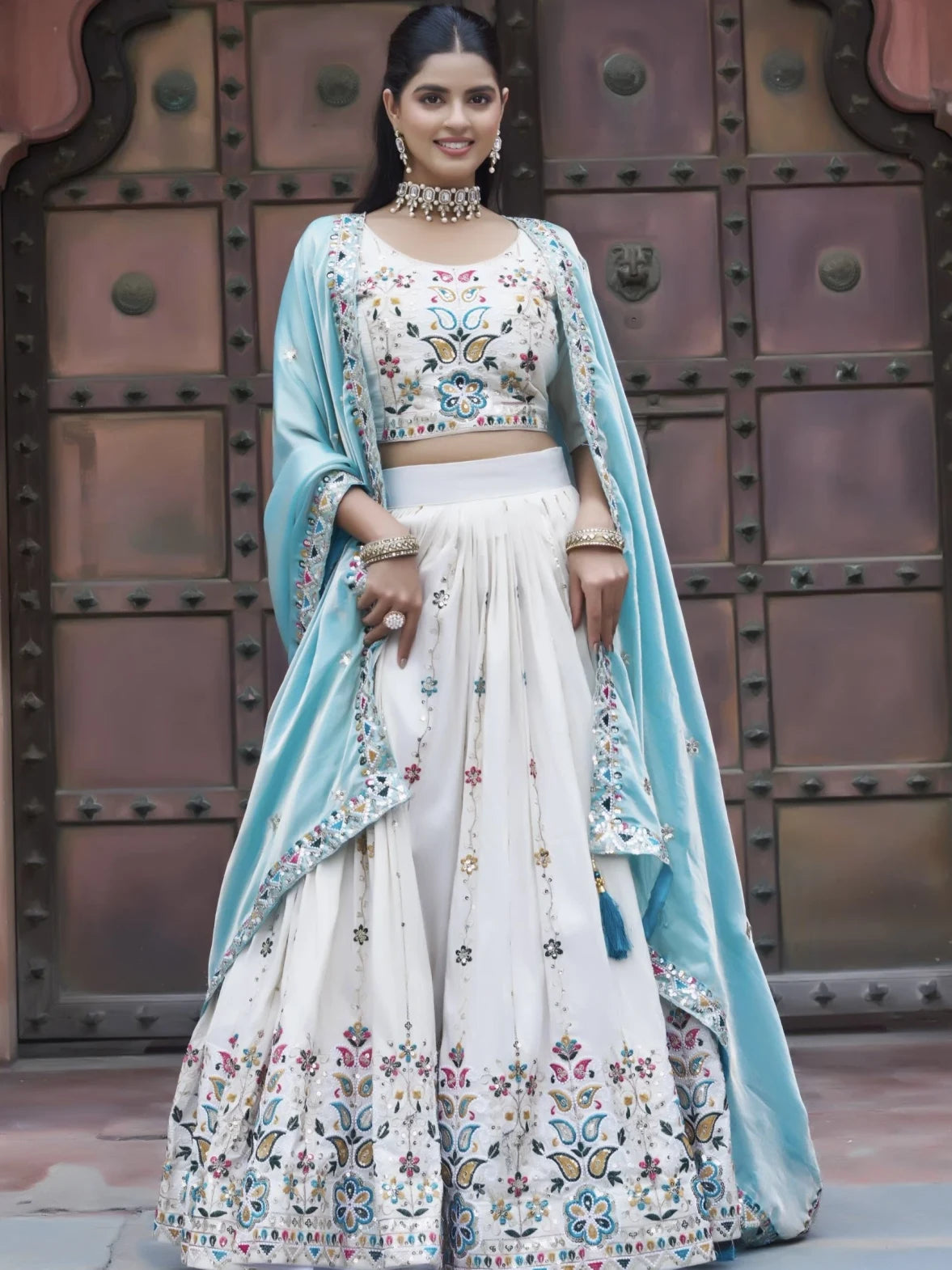 Woman in traditional outfit with floral patterns against a metallic background