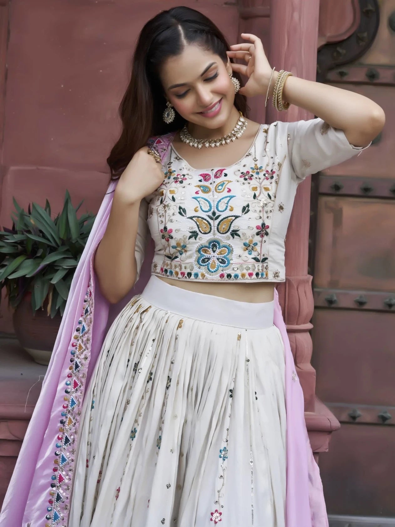 Woman wearing a traditional outfit with floral embroidery in an outdoor setting