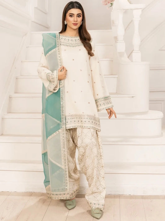 Woman in a traditional outfit with white and light blue design on a staircase.