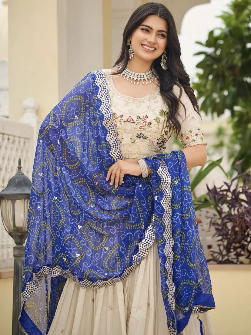 Woman wearing a traditional outfit with a blue shawl in an outdoor setting