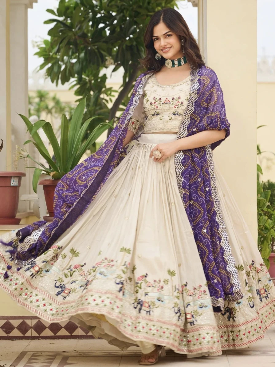 Woman wearing a traditional embroidered outfit with a purple shawl in an outdoor setting.