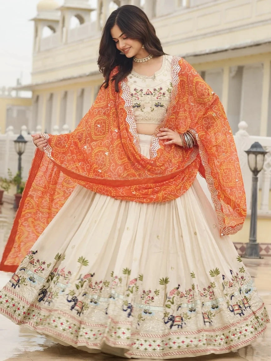 Woman wearing a traditional outfit with an orange dupatta in an outdoor setting