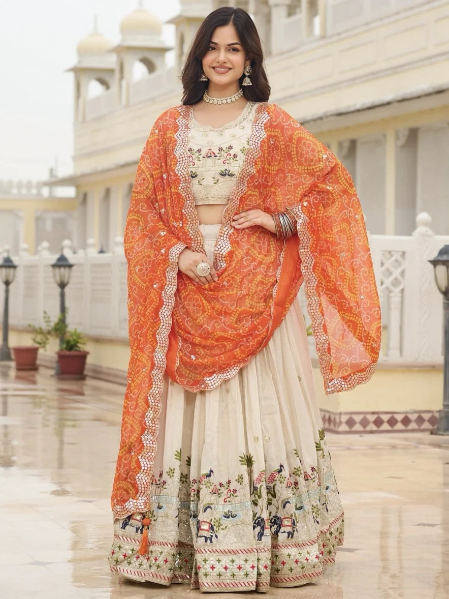 Woman in traditional outfit with orange dupatta in an outdoor setting
