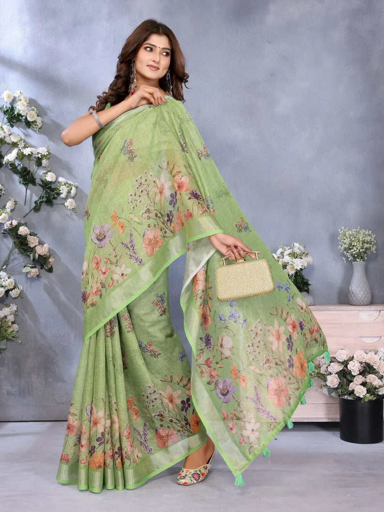 Woman wearing a green floral saree with a matching blouse, holding a handbag against a gray background with flowers.