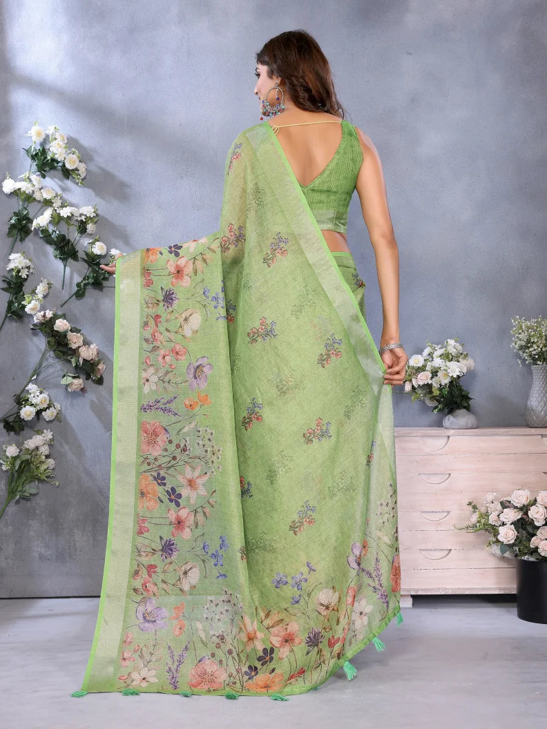Woman wearing a green saree with floral patterns in a decorated room.