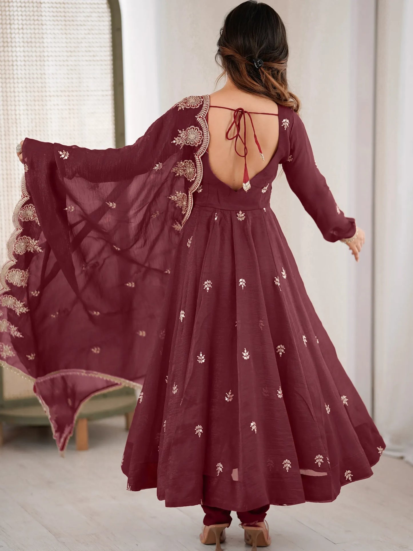 Maroon embroidered dress with open back worn by a person indoors.
