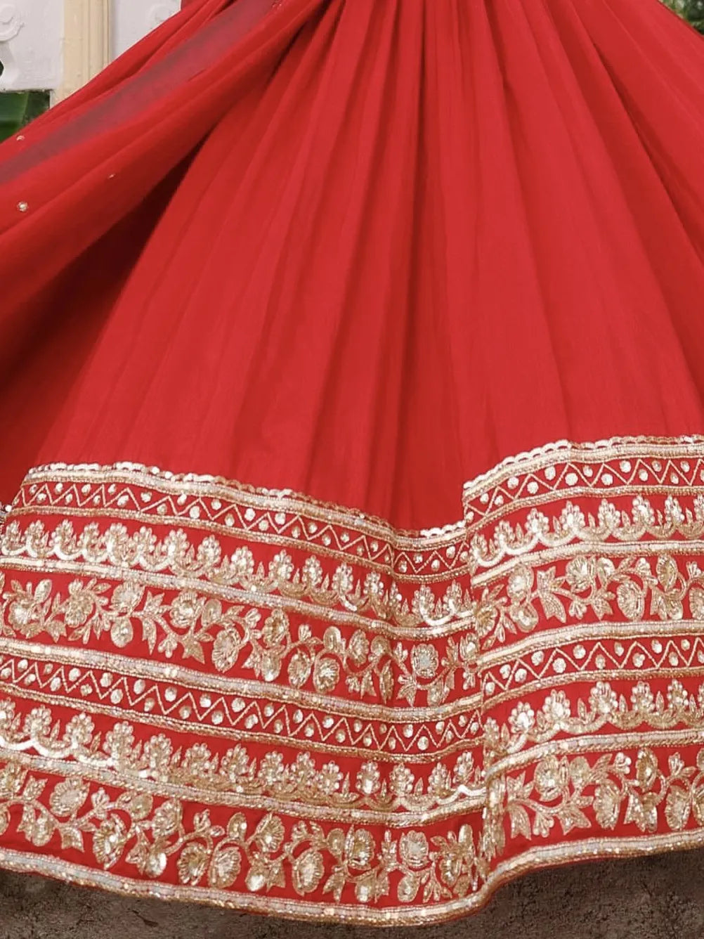 Close-up of a red fabric with intricate gold embroidery