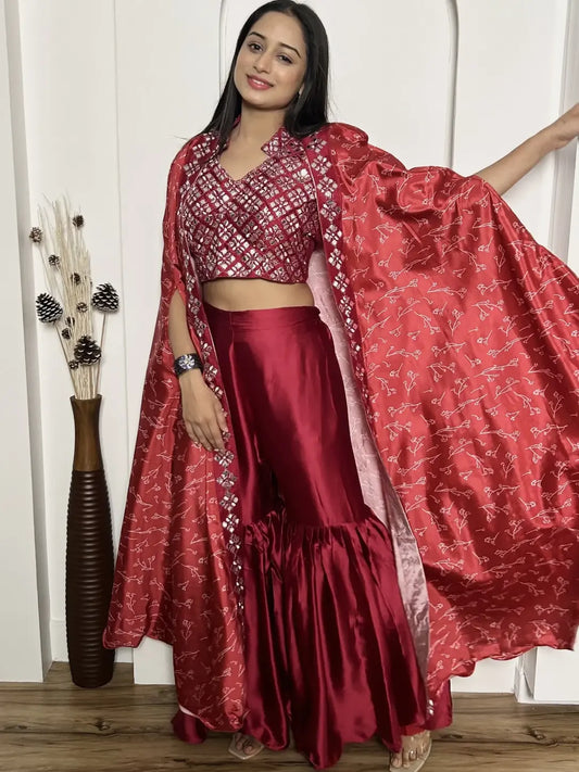 Woman wearing a red traditional outfit with a matching dupatta, standing indoors.