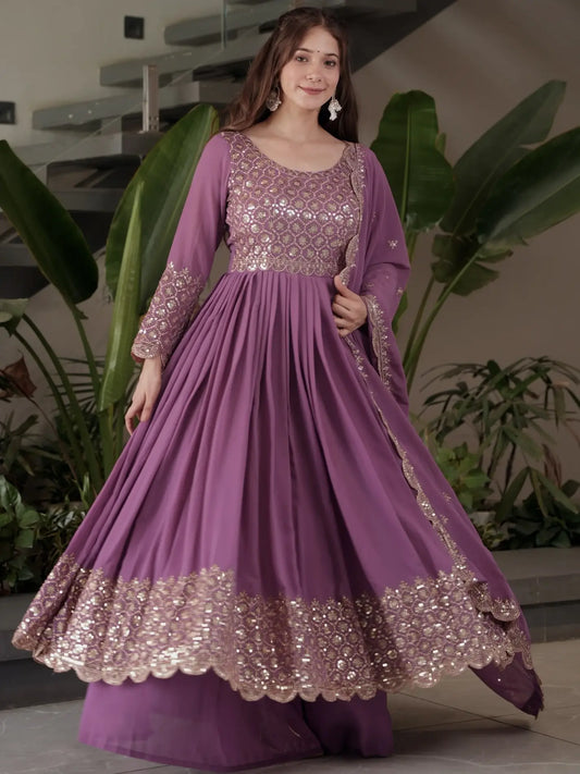 Woman wearing a purple traditional outfit with gold embroidery indoors.