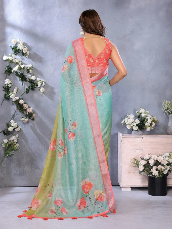 Woman wearing a light blue saree with floral patterns in a decorated room.