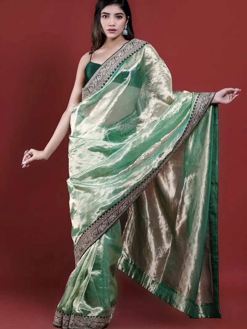Woman wearing a green saree with a red background