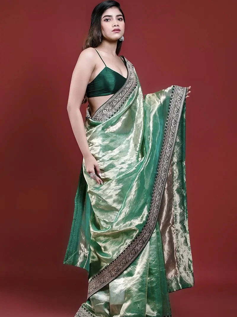 Woman wearing a green saree with a red background