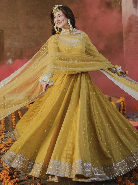 Woman in a yellow traditional outfit with a floral background