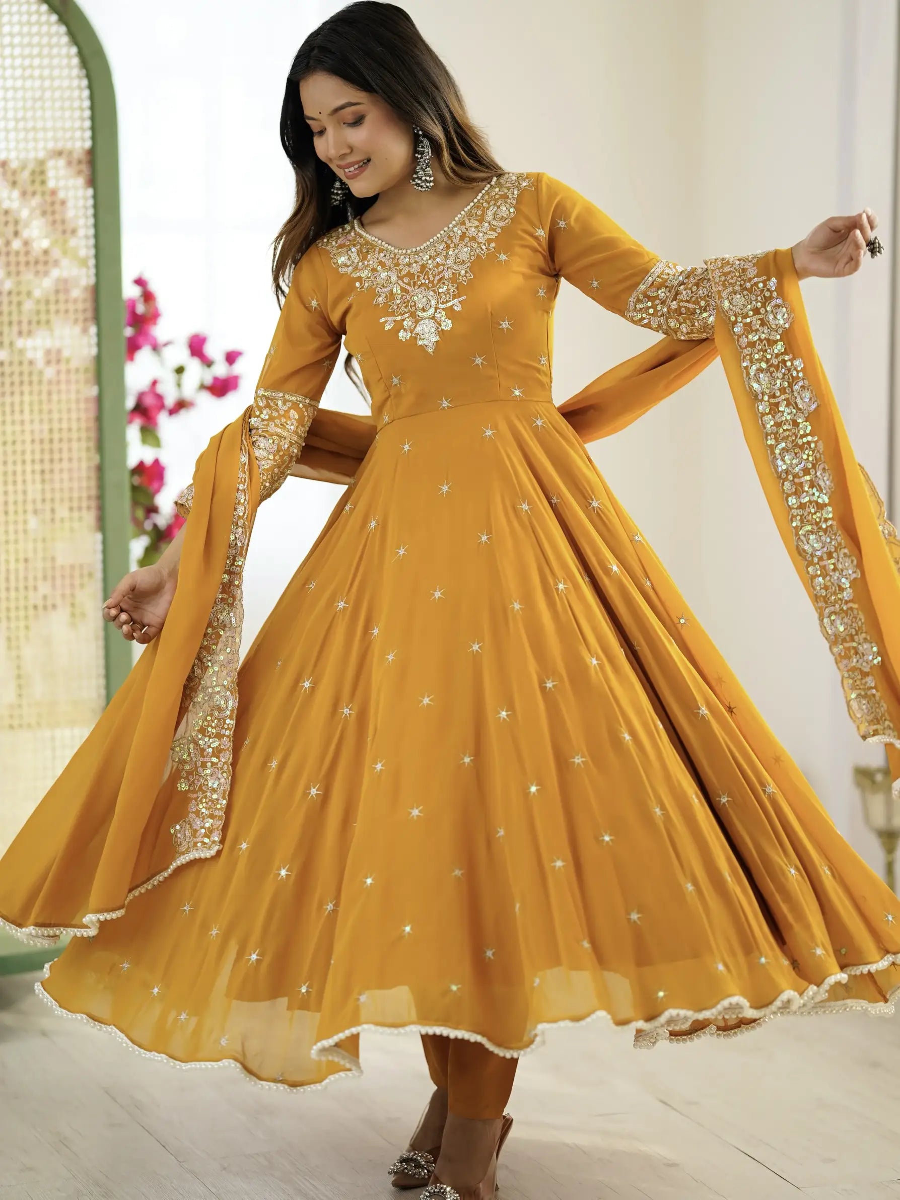 Woman wearing a yellow embroidered dress with a white background