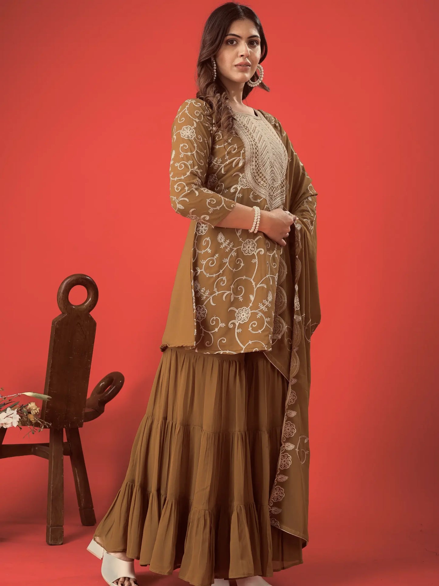 Woman wearing a brown traditional outfit with a red background