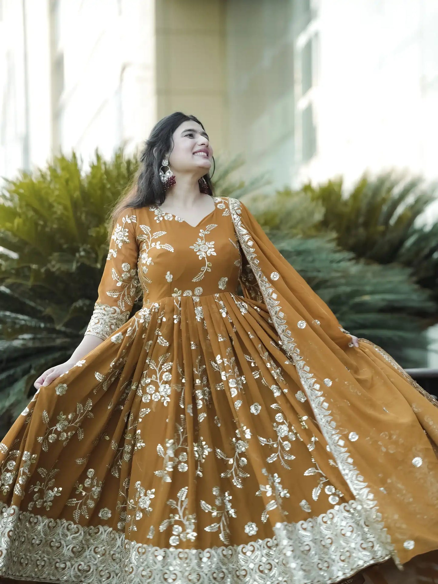 Woman wearing a mustard yellow dress with floral patterns in an outdoor setting
