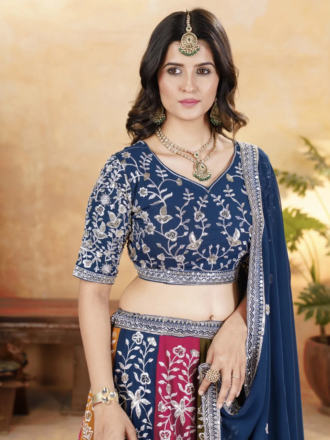Woman wearing a traditional blue embroidered saree with a blurred background