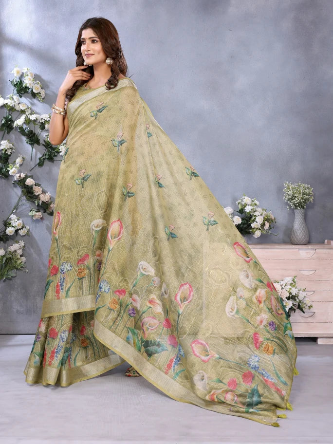 Woman wearing a light green saree with floral embroidery against a gray background