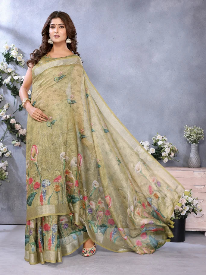 Woman wearing a light green saree with floral patterns in a decorated room.