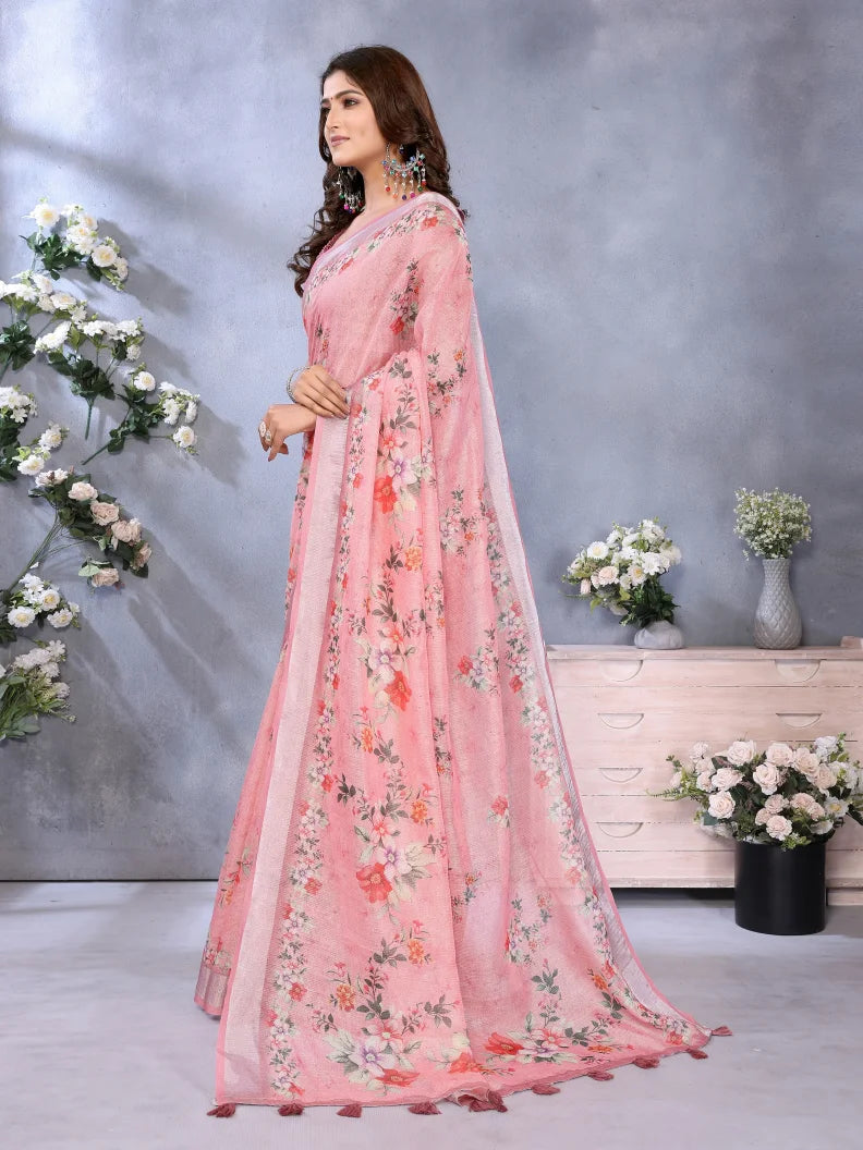Woman wearing a pink floral saree with a gray background and decorative flowers.