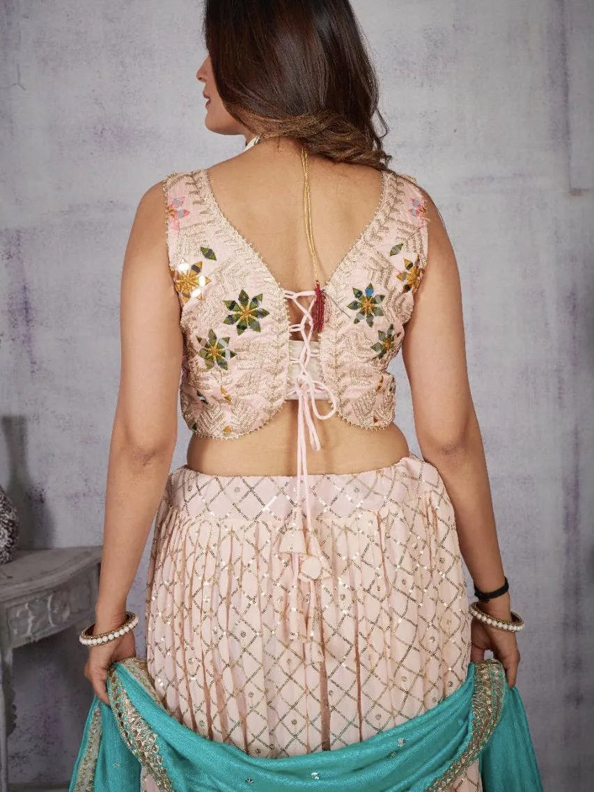 Woman wearing a traditional embroidered blouse and saree with a gray background