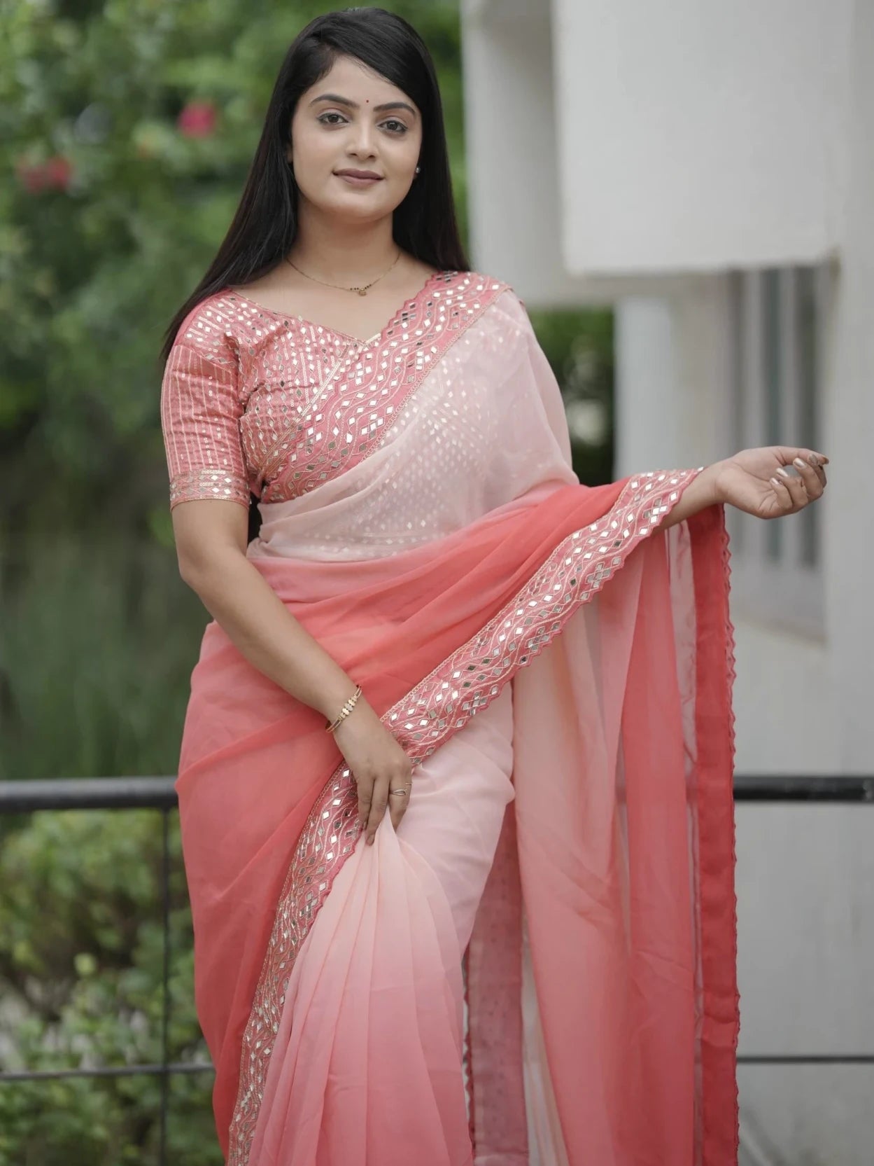 Woman wearing a pink saree with a blurred background
