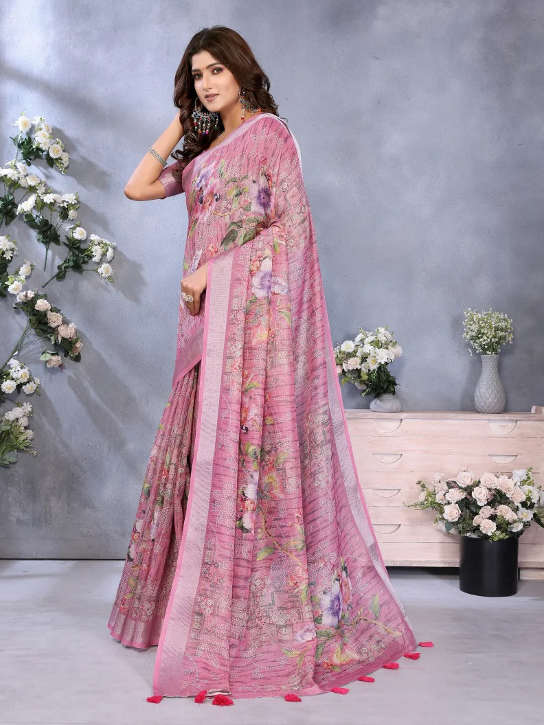 Woman wearing a pink saree with floral patterns in a decorated indoor setting.