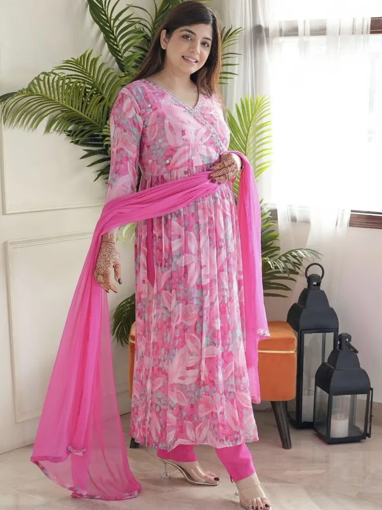Woman in a pink and white floral outfit with a matching dupatta in a well-lit room.